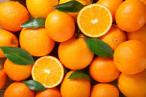 fresh orange fruits with leaves as background, top view Baladi Oranges